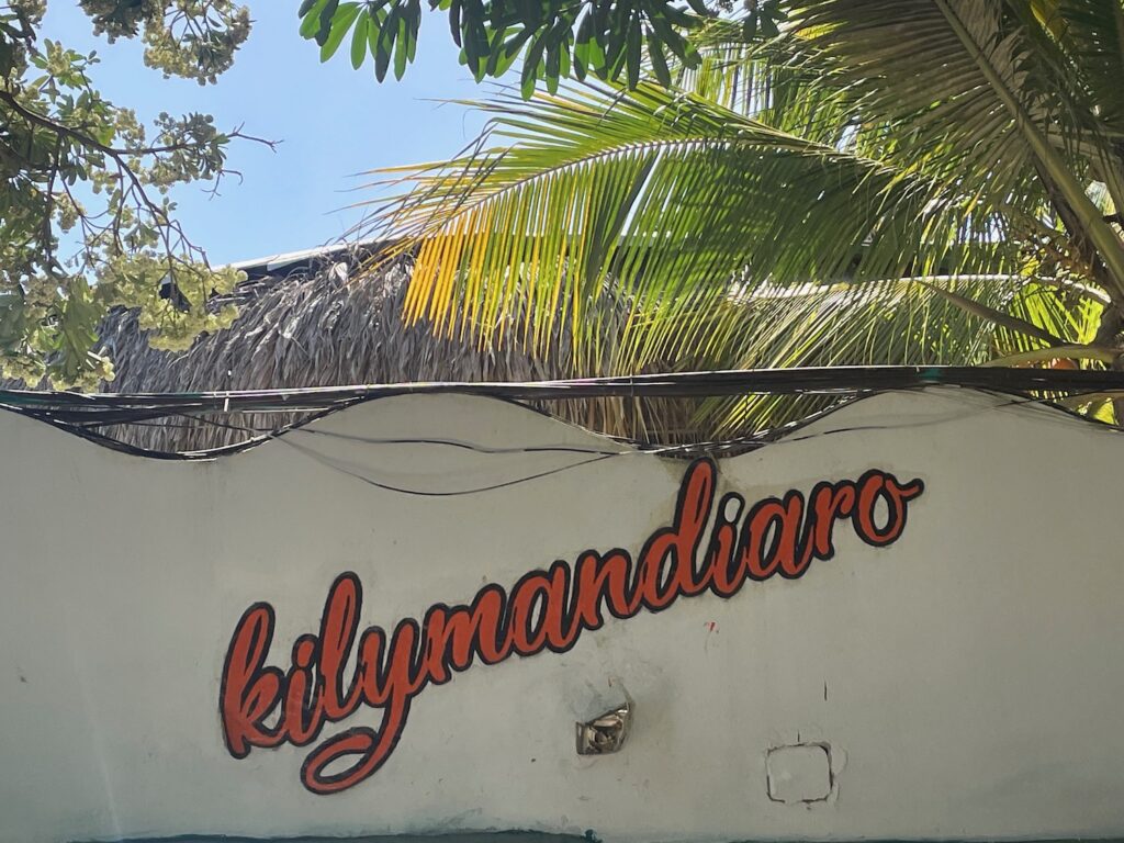 A handpainted sign on a wall announces the location of Kilymandiaro Sunset Paradise in Barranquilla, Colombia photo ©Kate Dana