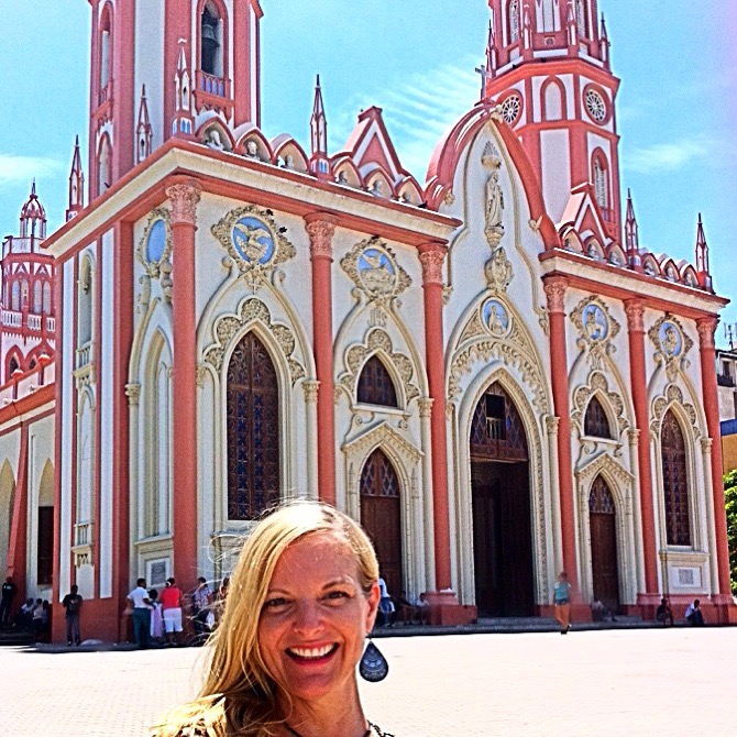Travel blogger Kate Dana in front of the colorful church, Parroque de San Nicholas in Barranquilla, Colombia ©Kate Dana